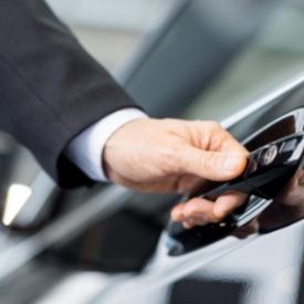 Contact Limo professional chauffeur opening luxury SUV door for client — Kenosha chauffeur service