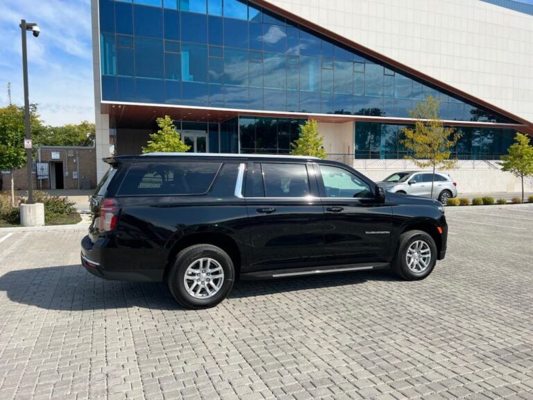 Contact Limo Suburban parked outside a glass-fronted corporate building