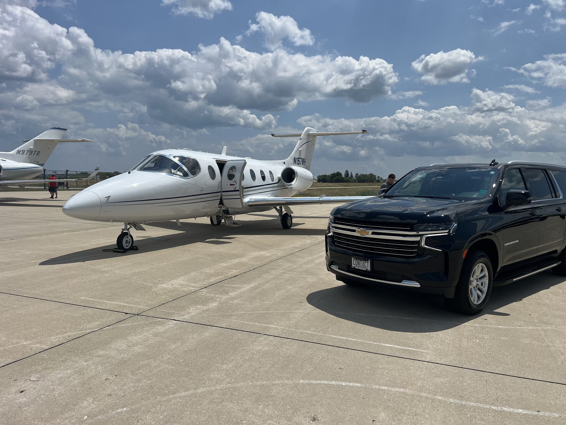 Contact Limo Suburban beside private jet on tarmac at executive airport, FBO pickup service near Chicago
