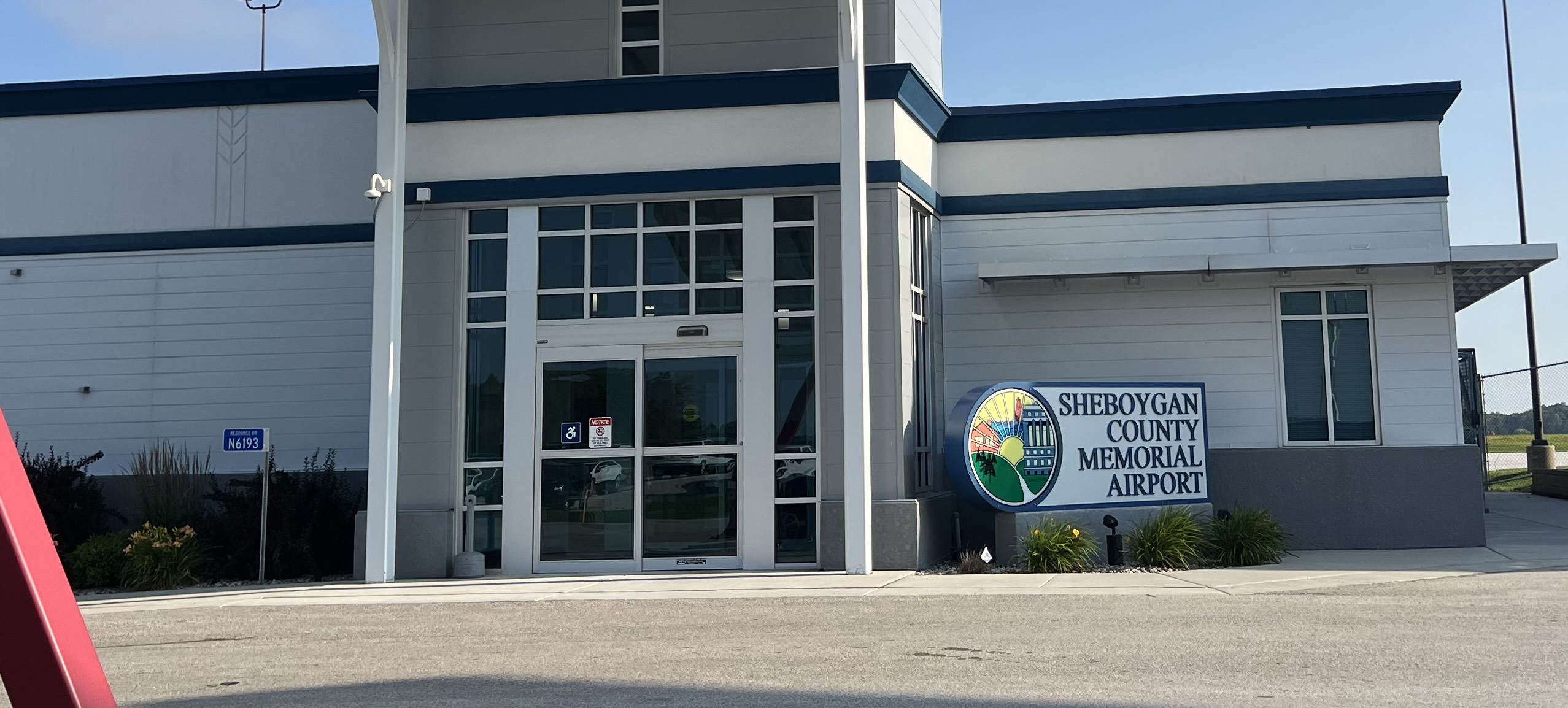 Sheboygan County Memorial Airport SBM terminal exterior with airport sign, Contact Limo service point