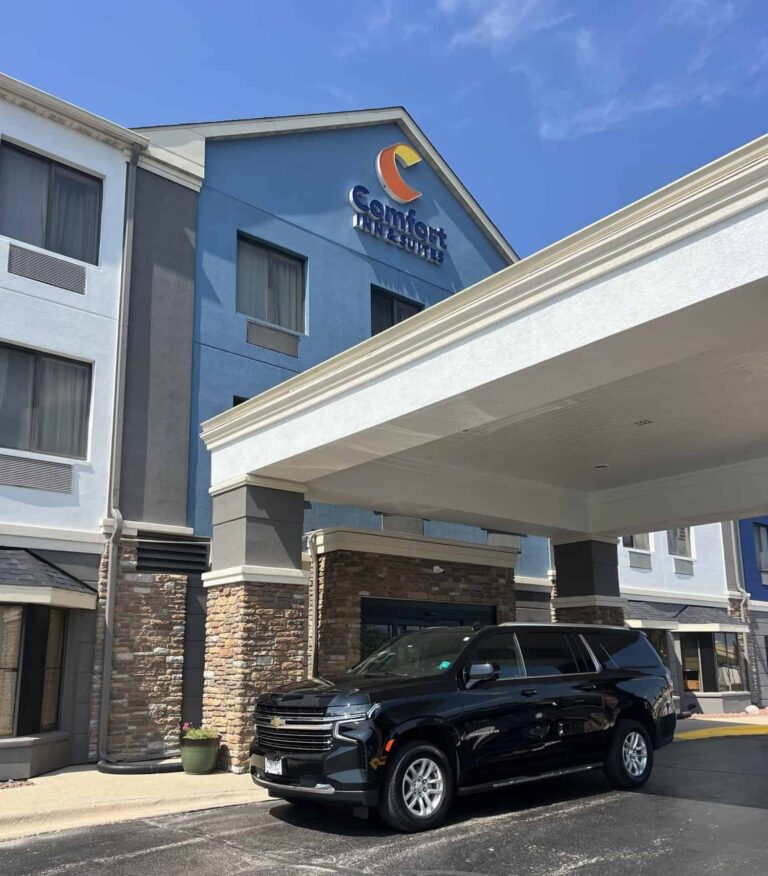 Contact Limo Suburban waiting under a hotel entrance canopy for a guest pickup