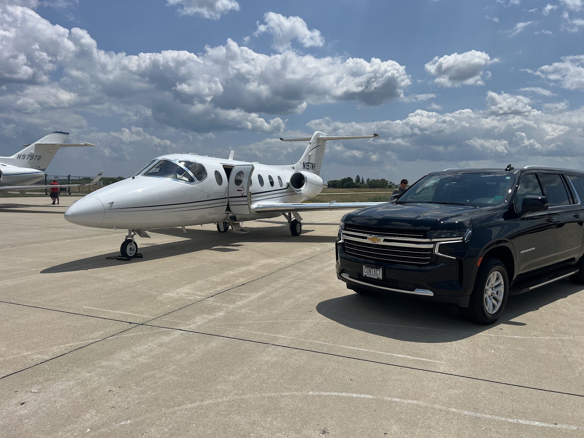 Contact Limo Suburban beside a private jet on the tarmac — FBO ground service